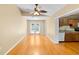 Bright living room featuring hardwood floors and a ceiling fan, leading to the kitchen and backyard at 3907 W Azeele St, Tampa, FL 33609