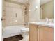 Bathroom with tile shower over tub, tile floor, wood cabinets, and solid surface countertop at 4503 Legacy Park Dr, Tampa, FL 33611