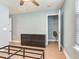 Bedroom with aqua walls, light wood floor, black dresser, open closet, and an unmade bed frame at 4503 Legacy Park Dr, Tampa, FL 33611
