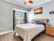 Bedroom featuring a large window, a ceiling fan, and warm lighting, providing a comfortable and inviting atmosphere at 4503 Legacy Park Dr, Tampa, FL 33611