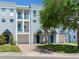 Multi-story condo building with a driveway and garage, featuring balconies and blue-accented entry doors at 4503 Legacy Park Dr, Tampa, FL 33611