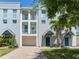 Three story condo building with garage and blue doors and balconies for each unit at 4503 Legacy Park Dr, Tampa, FL 33611