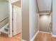 Hallway leading to a carpeted staircase with hardwood flooring and an open door to the living space at 4503 Legacy Park Dr, Tampa, FL 33611