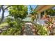 Green backyard pathway lined with lush plants and trees leads to a serene outdoor space at 4720 Coronado S Way, Gulfport, FL 33711