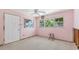 Bright pink bedroom with natural light from two windows, awaiting repairs and personalized decor at 4720 Coronado S Way, Gulfport, FL 33711