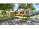 Side view of the house with lovely landscaping, a small yard, and mature trees providing shade at 4720 Coronado S Way, Gulfport, FL 33711