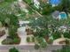 Aerial shot showing the house, mature trees, lush landscaping, and driveway leading to garage at 4901 W Estrella St, Tampa, FL 33629