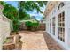 Backyard featuring brick pavers, lush greenery, and large windows for ample natural light at 4901 W Estrella St, Tampa, FL 33629