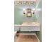 Stylish half bathroom with green walls, a decorative mirror, and a marble countertop with sink at 4901 W Estrella St, Tampa, FL 33629