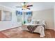 Cozy bedroom featuring hardwood floors, white bedding, and natural light from a window at 4901 W Estrella St, Tampa, FL 33629