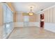 Elegant dining room with striped wallpaper, wainscoting, tile floors, a chandelier, and natural light at 4901 W Estrella St, Tampa, FL 33629