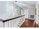 Upstairs hallway featuring hardwood floors, white trim and stairway, with a decorative pendant light at 4901 W Estrella St, Tampa, FL 33629