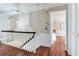 Upstairs hallway showcasing hardwood floors, white trim, decorative molding, and a pendant light at 4901 W Estrella St, Tampa, FL 33629