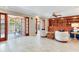Spacious living room with tile floors, a built-in bookshelf, comfortable seating, and access to sunroom at 4901 W Estrella St, Tampa, FL 33629