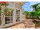 Charming brick patio with lush landscaping and bright flowers, accessible through glass paneled door at 4901 W Estrella St, Tampa, FL 33629