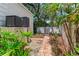 Side yard featuring tropical landscaping, brick pavers, and external storage at 4901 W Estrella St, Tampa, FL 33629