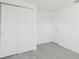 Bedroom with gray flooring, white walls and trim, and closet and door at 7516 S Obrien St, Tampa, FL 33616