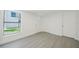 Bright bedroom features gray flooring, white walls and trim, doors, and a window at 7516 S Obrien St, Tampa, FL 33616