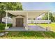 Carport and shed combo in a fenced backyard with green grass at 7516 S Obrien St, Tampa, FL 33616