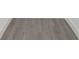 Close up of newly installed gray laminate flooring, white baseboard trim at 7516 S Obrien St, Tampa, FL 33616