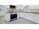 Well-lit kitchen featuring white cabinets, gray countertops, and stainless steel appliances at 7516 S Obrien St, Tampa, FL 33616