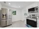 Modern kitchen with stainless steel refrigerator, white cabinets, granite counters and a new oven at 7516 S Obrien St, Tampa, FL 33616