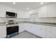 Modern kitchen featuring white cabinets, stainless steel appliances, and gray countertops at 7516 S Obrien St, Tampa, FL 33616