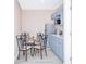 Compact kitchen featuring blue cabinets, stainless appliances, and glass top dining table at 7542 Armand Cir, Tampa, FL 33634