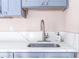 Kitchen sink featuring white quartz countertops and a modern curved faucet at 7542 Armand Cir, Tampa, FL 33634