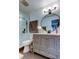 This bathroom features a gray vanity, round mirror, and glass enclosed shower at 9481 Highland Oak Dr # 1308, Tampa, FL 33647