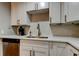 Updated kitchen sink and countertop, featuring sleek white cabinets and stainless-steel dishwasher at 9481 Highland Oak Dr # 1308, Tampa, FL 33647