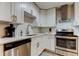 The renovated kitchen features white cabinetry, stainless steel appliances, and a tile backsplash at 9481 Highland Oak Dr # 1308, Tampa, FL 33647