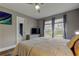 Airy main bedroom features a ceiling fan, a television, and backyard views through updated windows at 9481 Highland Oak Dr # 1308, Tampa, FL 33647