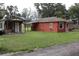 Exterior view of home and utility shed, surrounded by lawn and gravel parking at 1006 Gray St, Plant City, FL 33563