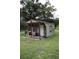 Charming cottage with covered porch surrounded by lush green lawn and mature trees at 1006 Gray St, Plant City, FL 33563