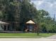 Community playground with swings and climbing structure, surrounded by mature trees at 10109 36Th E Ct, Parrish, FL 34219