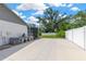 Paved backyard area featuring the house's air conditioning system, with the backyard and white fence behind it at 10811 Providence Oaks Dr, Riverview, FL 33578