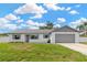 Well-maintained home with a white exterior, gray accents, and a spacious two-car garage at 10811 Providence Oaks Dr, Riverview, FL 33578