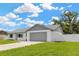 This home features a gray roof, white exterior, and a wide two-car garage with ample curb appeal at 10811 Providence Oaks Dr, Riverview, FL 33578