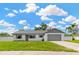 Charming single-story home with well-maintained lawn, fresh paint, and attached garage on a beautiful cloud filled day at 10811 Providence Oaks Dr, Riverview, FL 33578