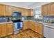 Updated kitchen with stainless steel appliances, mosaic backsplash, and wood cabinets and hardwood flooring at 10811 Providence Oaks Dr, Riverview, FL 33578