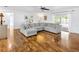 Inviting living room showcasing hardwood floors, a large sectional couch, and sliding doors to the screened lanai at 10811 Providence Oaks Dr, Riverview, FL 33578
