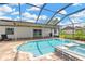 Relaxing backyard pool area with screened lanai, brick trim, and built-in jacuzzi area for summer fun at 10811 Providence Oaks Dr, Riverview, FL 33578