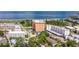 This aerial view highlights the building near a park, tennis courts, and beautiful beaches with clear blue waters at 1120 N Shore Ne Dr # 503, St Petersburg, FL 33701