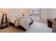 Cozy bedroom with neutral carpet, a plush queen bed, and a bright window overlooking palm trees at 1120 N Shore Ne Dr # 503, St Petersburg, FL 33701