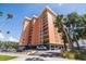 View of condo building with multiple levels of balconies and covered parking and mature landscaping at 1120 N Shore Ne Dr # 503, St Petersburg, FL 33701