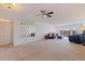 Bright living room with plush carpet, ceiling fan, and sliding glass doors to a balcony at 1120 N Shore Ne Dr # 503, St Petersburg, FL 33701