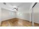 Simple bedroom featuring hardwood floors, ceiling fan, and windows, plus mirrored closet at 11460 Park Blvd, Seminole, FL 33772