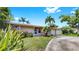 Charming single-story home with a well-manicured lawn and beautiful tropical landscaping at 11460 Park Blvd, Seminole, FL 33772