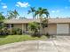 Charming single-story home featuring a lush tropical landscape, a one-car garage, and a well-maintained lawn at 11460 Park Blvd, Seminole, FL 33772